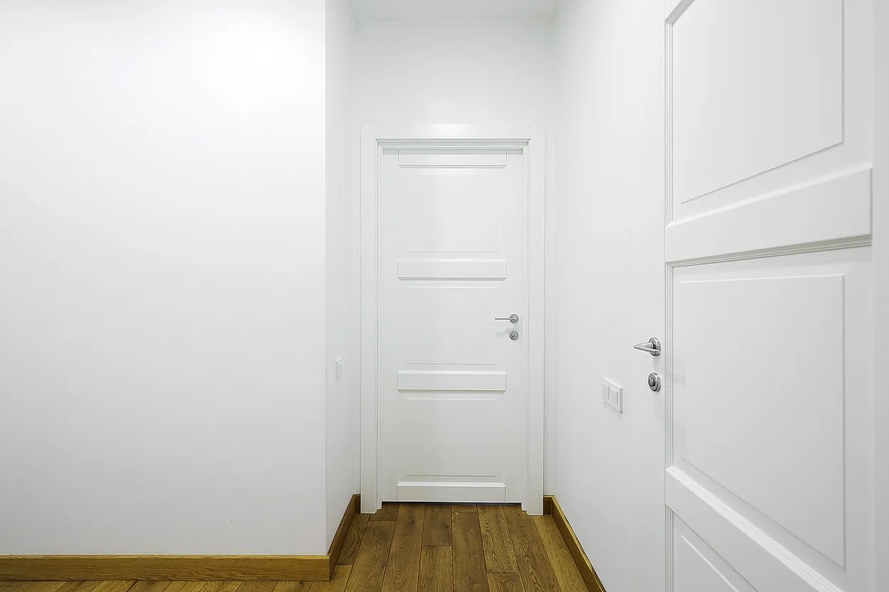 vista de pasillo blanco de vivienda con sus puertas